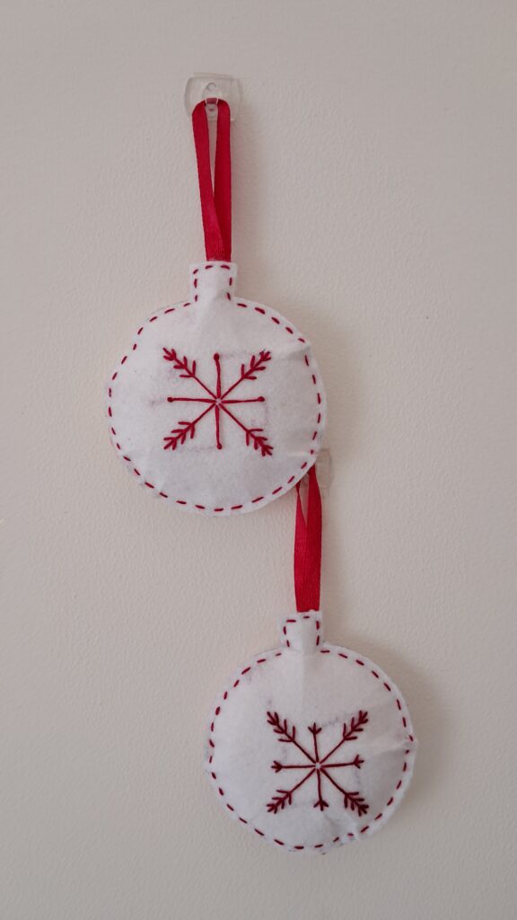 3" round christmas ornament made on felt fabric with red color embroidery, satin ribbon attached for hanging