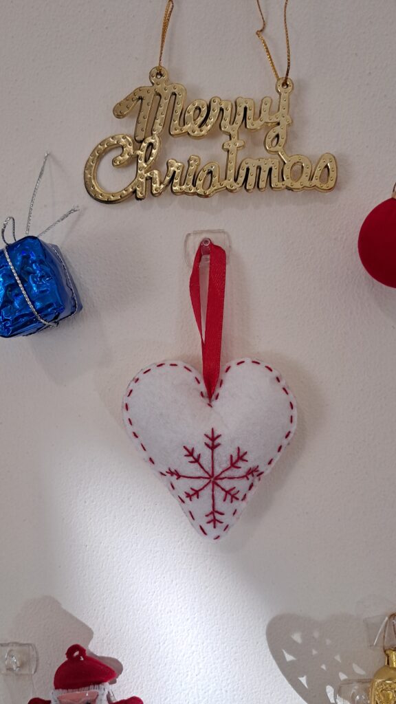 3" Heart shaped christmas ornament made with felt fabric, embroidered using red thread, satin ribbon attached for hanging